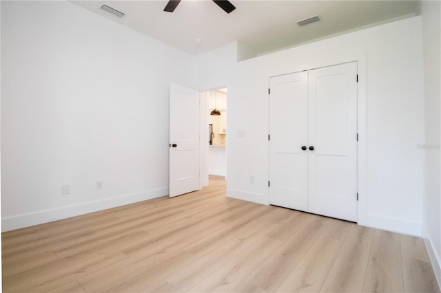 unfurnished bedroom with light hardwood / wood-style flooring, ceiling fan, and a closet