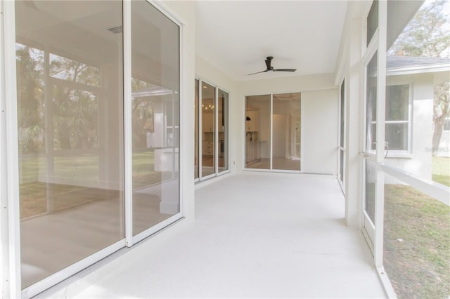 unfurnished sunroom with ceiling fan