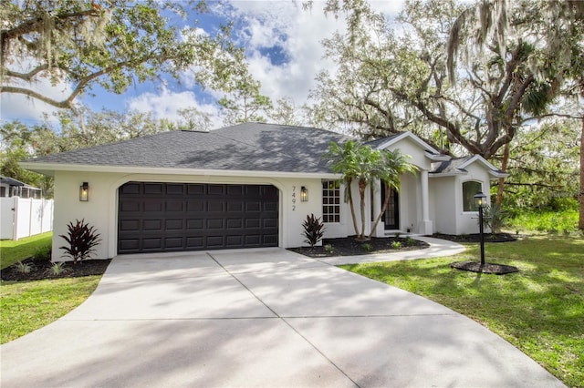 single story home featuring a garage and a front lawn