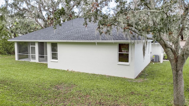 view of property exterior with a sunroom, a lawn, and central AC