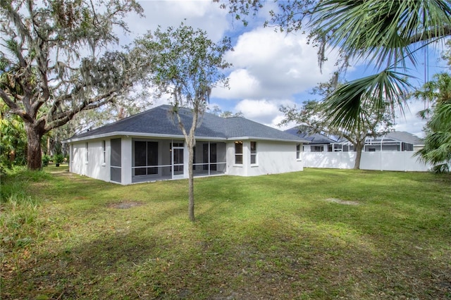 back of house with a lawn and a sunroom