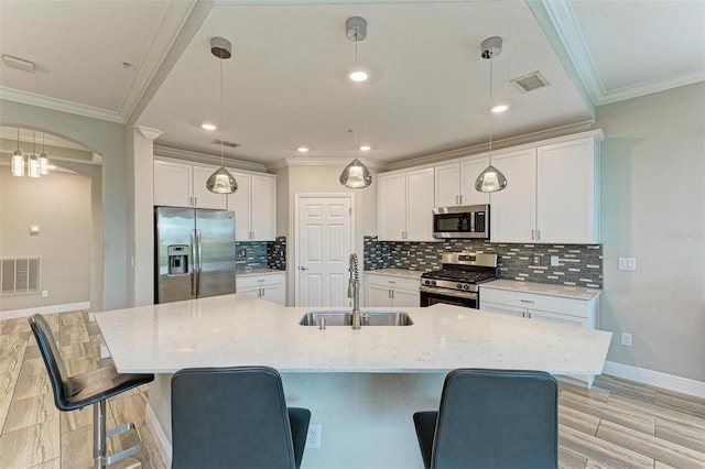 kitchen with white cabinetry, sink, a kitchen breakfast bar, and stainless steel appliances