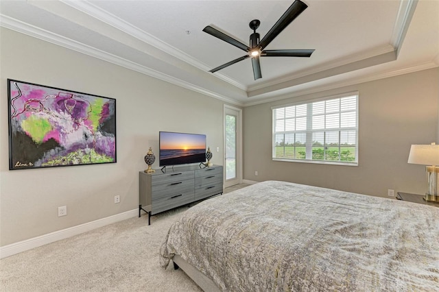 bedroom with ornamental molding, a tray ceiling, light carpet, and ceiling fan