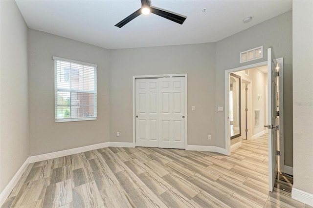 unfurnished bedroom with a closet, light wood-type flooring, and ceiling fan