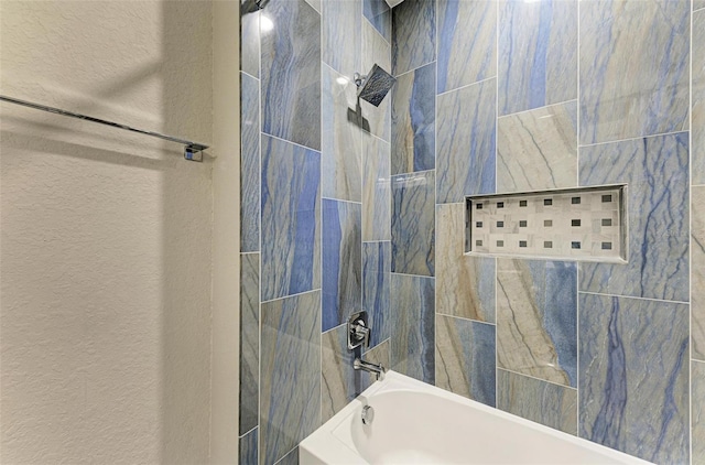 bathroom featuring tiled shower / bath