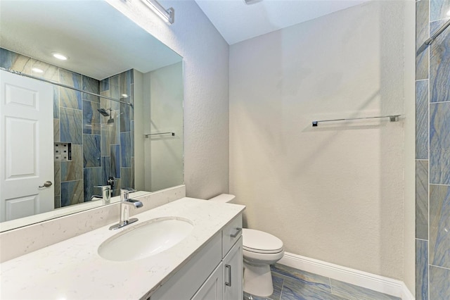 bathroom with walk in shower, vanity, and toilet