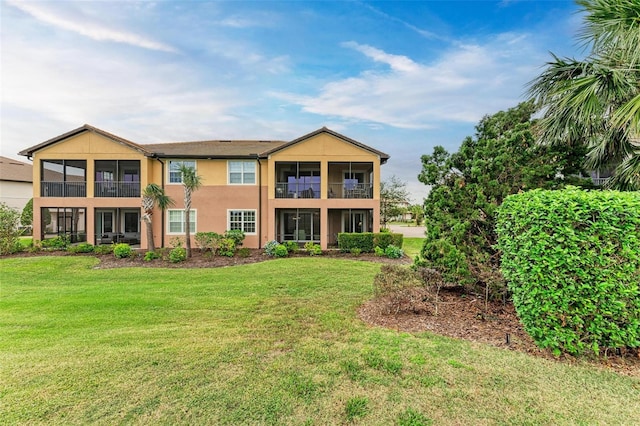 view of front of property featuring a balcony and a front yard