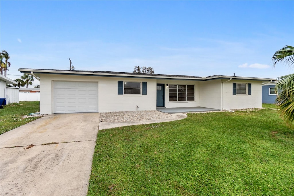 single story home featuring a garage and a front lawn