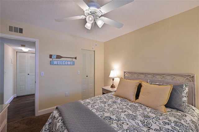 bedroom featuring ceiling fan, dark hardwood / wood-style floors, a closet, and a textured ceiling