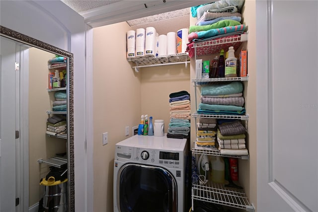 washroom with a textured ceiling and washer / dryer