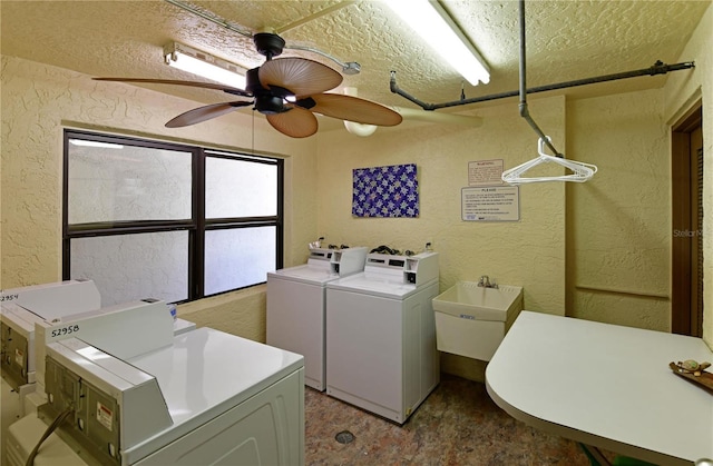 clothes washing area with washing machine and dryer, ceiling fan, and sink