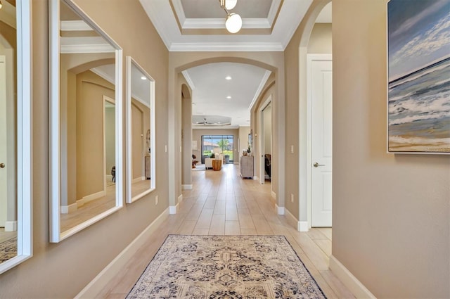 corridor with light hardwood / wood-style floors and ornamental molding