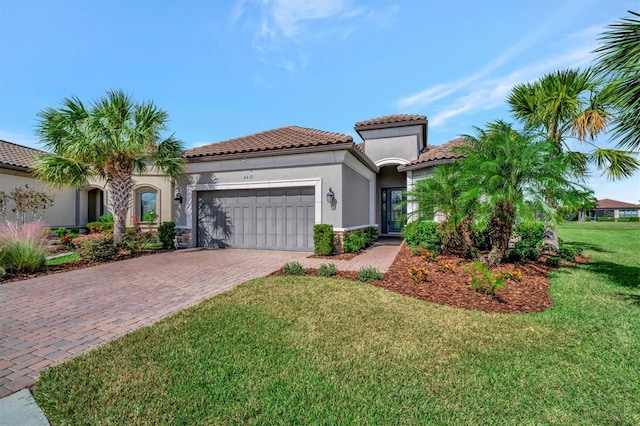 mediterranean / spanish-style house featuring a garage and a front lawn