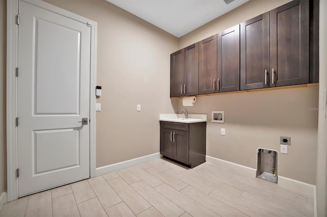 washroom with sink, cabinets, washer hookup, hookup for an electric dryer, and light hardwood / wood-style flooring