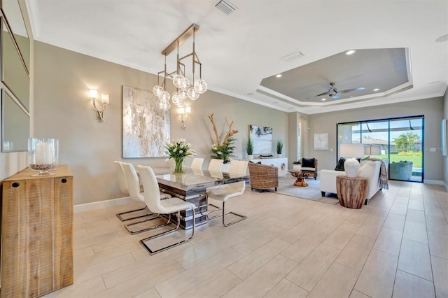 dining space with ceiling fan, light hardwood / wood-style floors, a raised ceiling, and ornamental molding