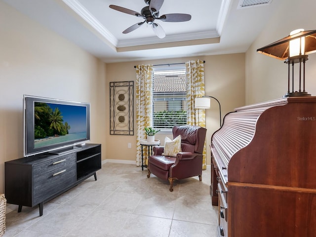 living area featuring ornamental molding, ceiling fan, and a raised ceiling