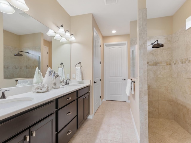 bathroom featuring vanity, tile patterned floors, and a tile shower