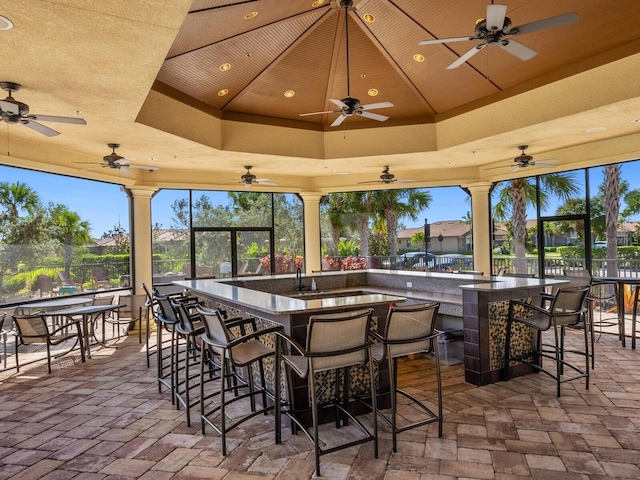 view of patio with ceiling fan and an outdoor bar