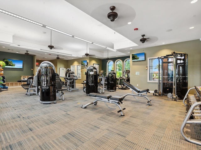 gym with a tray ceiling and carpet flooring