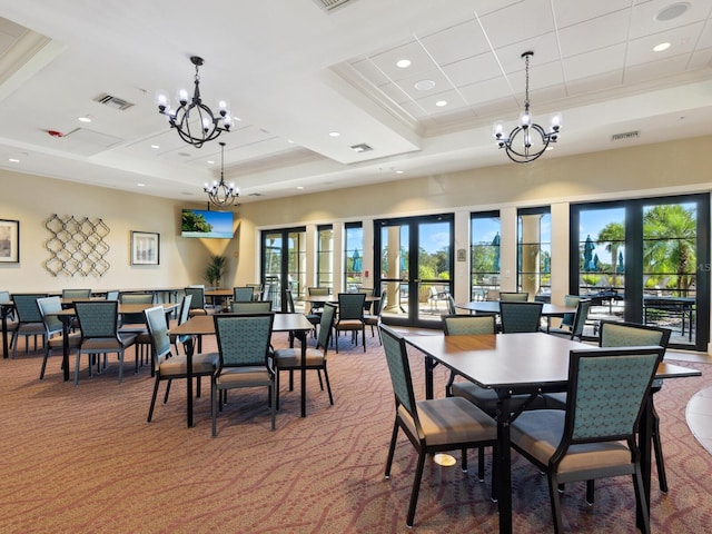 carpeted dining area featuring a raised ceiling, french doors, and ornamental molding