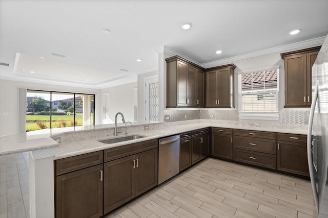 kitchen with sink, stainless steel appliances, light stone counters, kitchen peninsula, and decorative backsplash