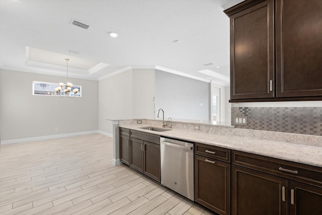 kitchen featuring tasteful backsplash, light hardwood / wood-style floors, sink, dishwasher, and a chandelier