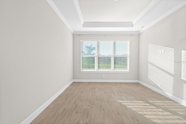 unfurnished room featuring a tray ceiling, light hardwood / wood-style flooring, and ornamental molding