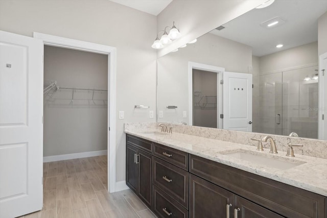 bathroom featuring hardwood / wood-style flooring, vanity, and an enclosed shower