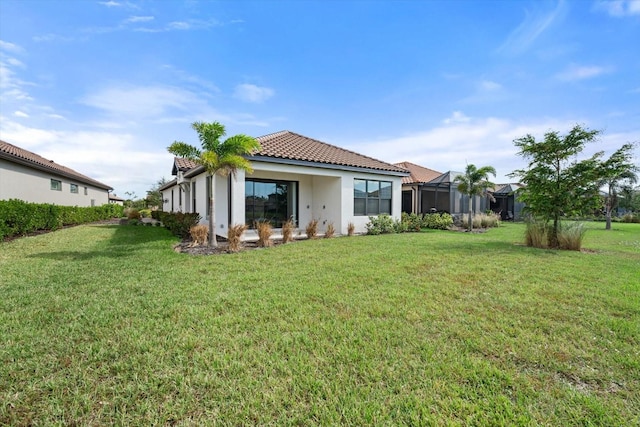 back of property featuring a lanai and a yard