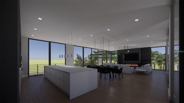 kitchen featuring a large island, a water view, a wall of windows, and dark wood-type flooring