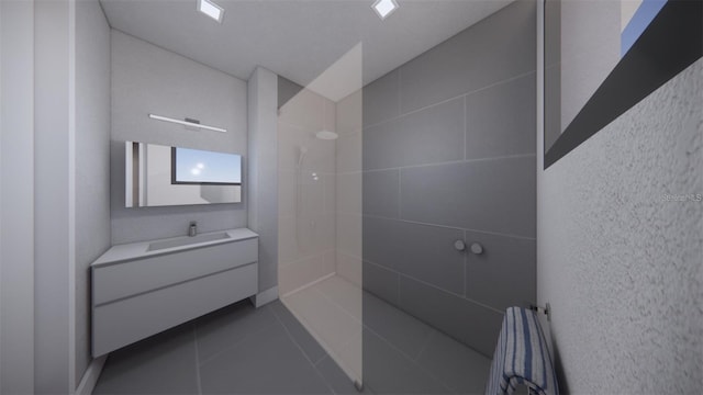 bathroom featuring tile patterned flooring, vanity, and a tile shower