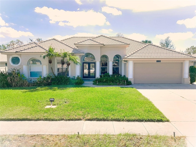 mediterranean / spanish-style home featuring a garage and a front yard