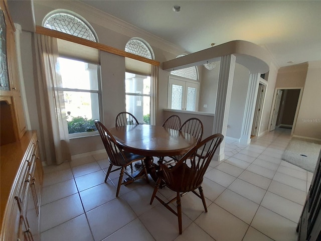 tiled dining room featuring ornamental molding and french doors