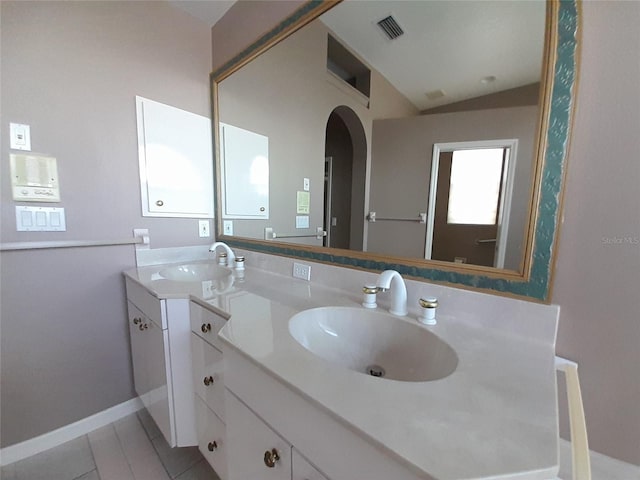 bathroom featuring vanity, tile patterned floors, and vaulted ceiling