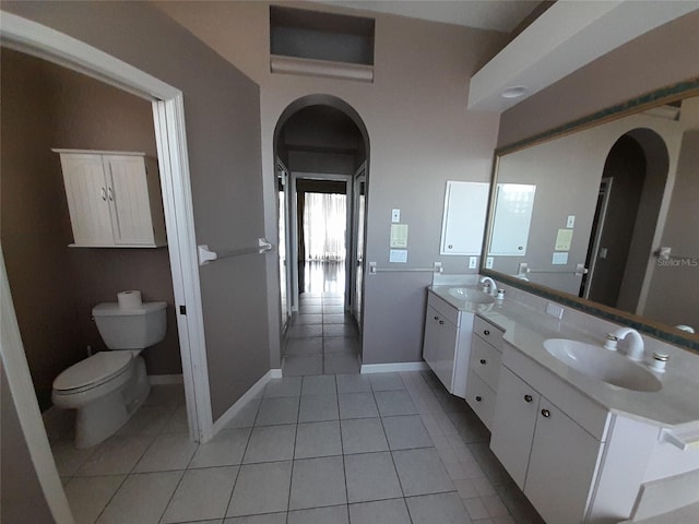 bathroom with toilet, vanity, and tile patterned floors