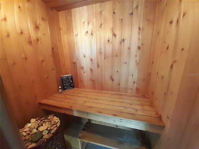 view of sauna with wood walls and tile patterned floors