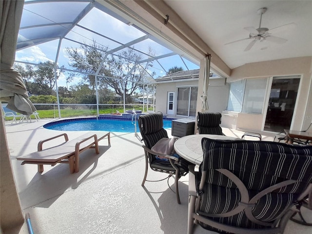 view of swimming pool featuring glass enclosure, a patio area, and ceiling fan