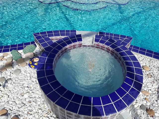 view of swimming pool featuring an in ground hot tub