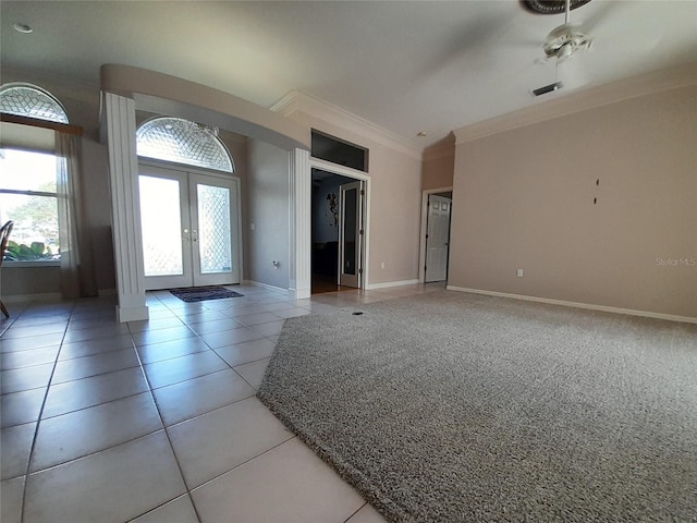 tiled foyer entrance with ceiling fan, crown molding, and french doors