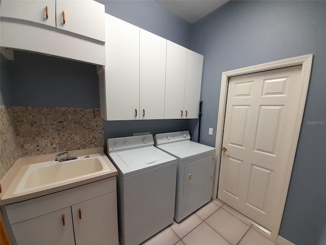 washroom featuring light tile patterned floors, cabinets, sink, and washer and dryer