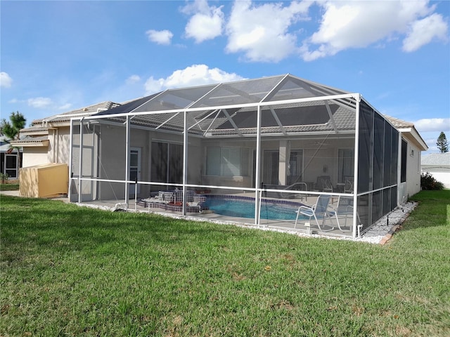 back of house with a patio area, a yard, and a lanai