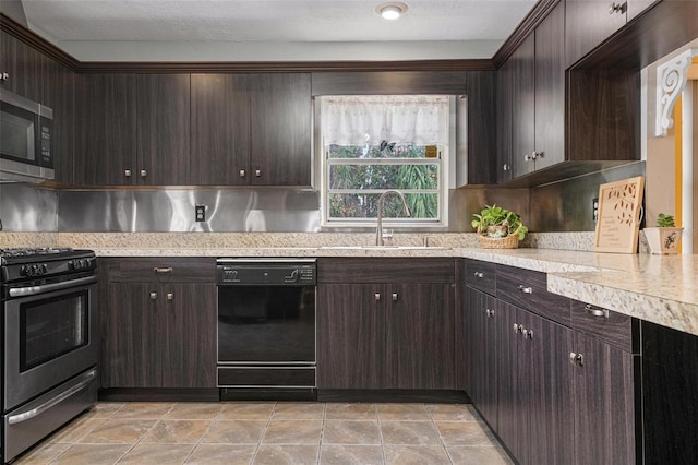 kitchen featuring a textured ceiling, dark brown cabinetry, stainless steel appliances, and sink