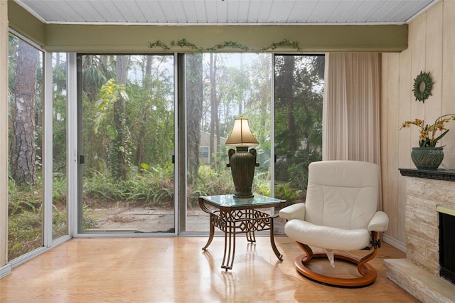 sunroom / solarium featuring a stone fireplace and a wealth of natural light