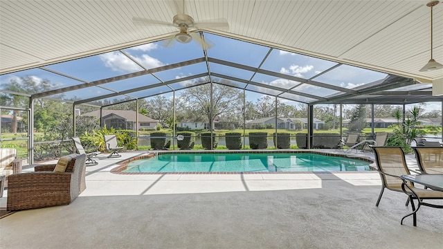 view of pool with ceiling fan, glass enclosure, and a patio