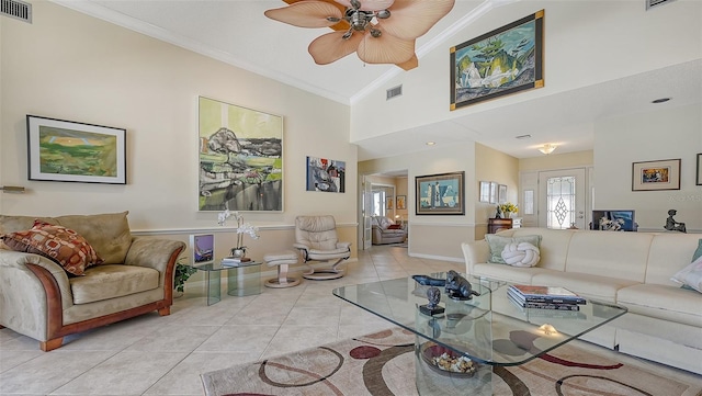 living room with ceiling fan, light tile patterned flooring, ornamental molding, and vaulted ceiling