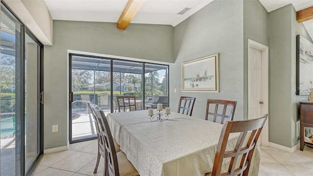 dining room with a textured ceiling, light tile patterned floors, and beam ceiling