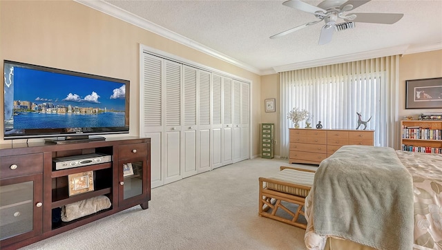 carpeted bedroom with ceiling fan, a textured ceiling, a closet, and ornamental molding