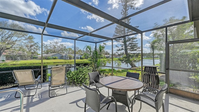 sunroom featuring a water view