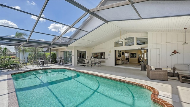 view of pool with an outdoor living space, a patio area, glass enclosure, and area for grilling