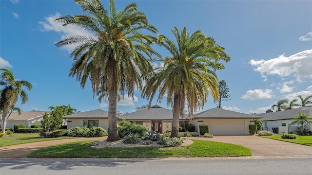 ranch-style home featuring a garage and a front yard